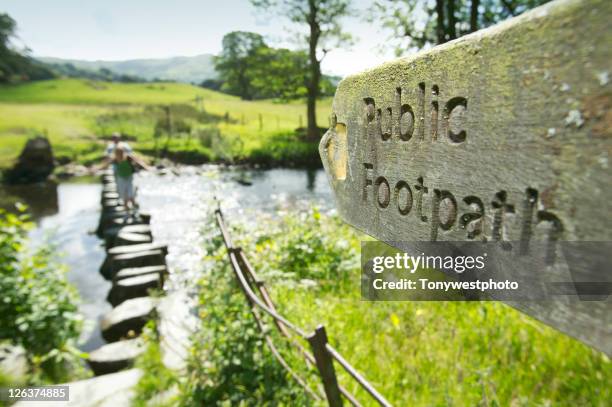 public footpath sign pointing to river with stepping stone showing - ambleside stock pictures, royalty-free photos & images