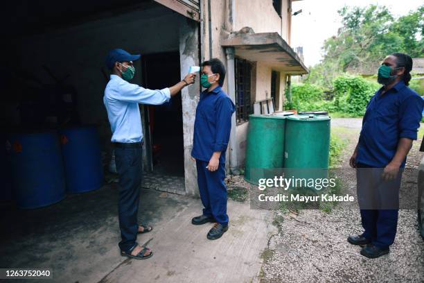 staff being checked for body temperature before entering factory - india covid stock pictures, royalty-free photos & images