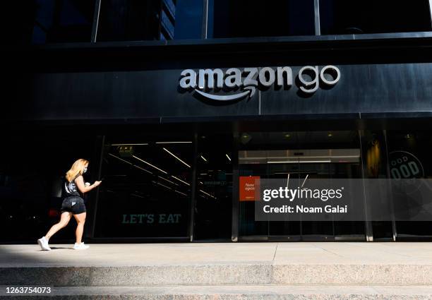 Person wears a face mask outside Amazon Go store as the city continues Phase 4 of re-opening following restrictions imposed to slow the spread of...