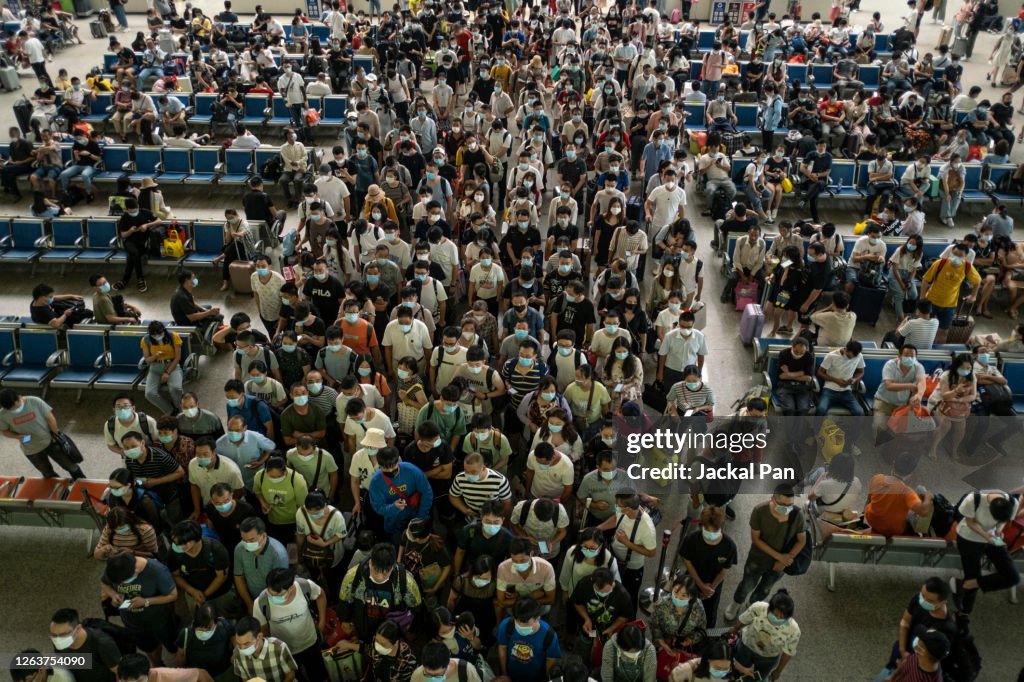 Passengers in line wearing protective masks at Hankou railway station in Wuhan