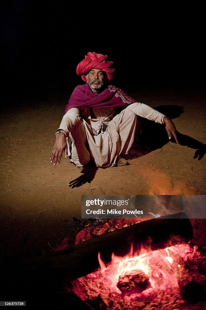 Bishnoi man sitting by fire, Rajasthan, India