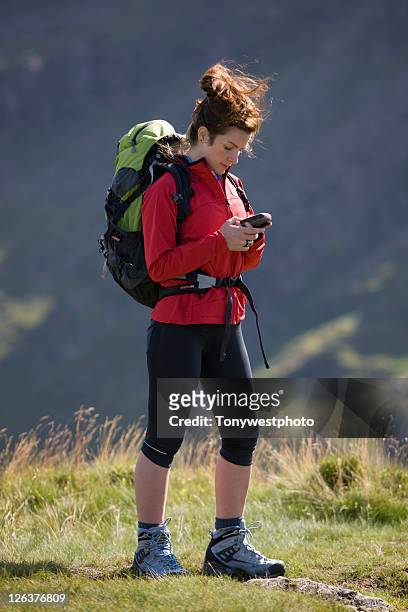 caucasian female (20's) hiker with gps unit - satnav photos et images de collection