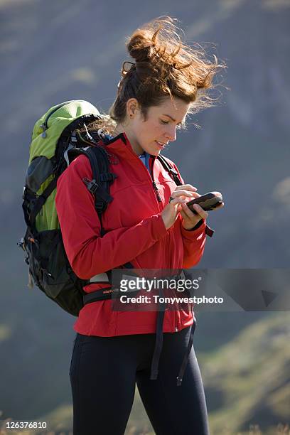 caucasian female (20's) hiker with gps unit - satnav photos et images de collection