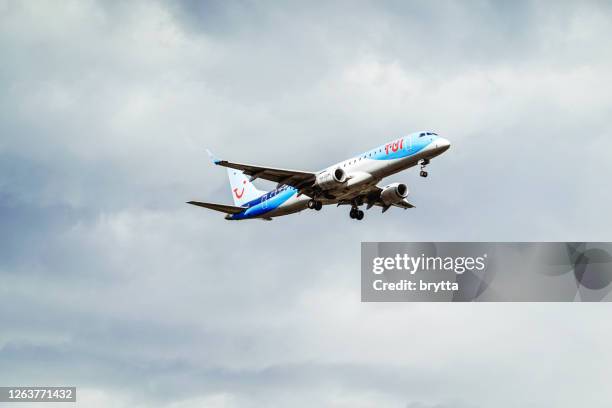 avión embraer de tui airlines bélgica acercándose al aeropuerto de bruselas en bélgica - tui ag fotografías e imágenes de stock