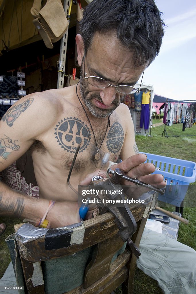 Caucasian artist making jewellery, Solfest, Cumbria UK