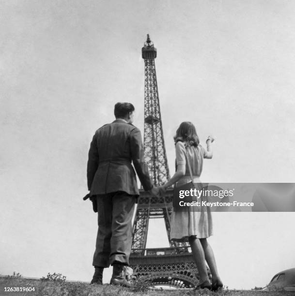 Soldat américain en couple avec une parisienne devant la tour Eiffel, à Paris, en 1944, France.