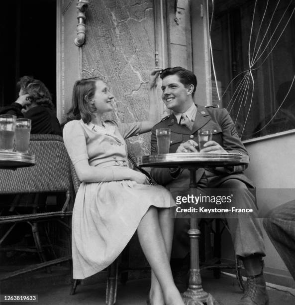 Soldat américain en couple avec une femme parisienne à la terrasse d'un café, à Paris, en 1944, France.