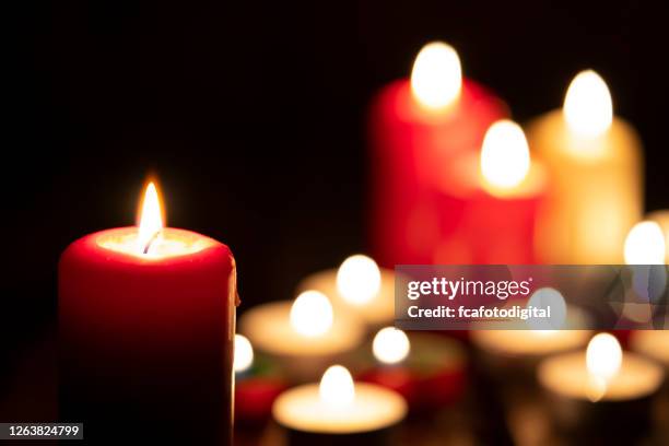 velas ardientes en la oscuridad - luto fotografías e imágenes de stock