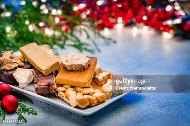 variout arten von spanischen turron auf weihnachtstisch - almonds and chocolate stock-fotos und bilder