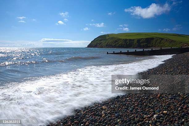 view from the water's edge on st. bees beach, looking towards st. bees head on the cumbrian coast - st bees stock pictures, royalty-free photos & images