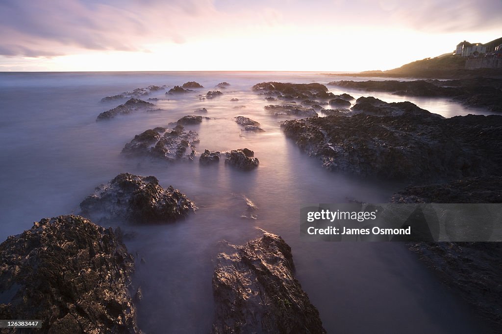 Sunset over the rocks at Croyde Bay in Devon.