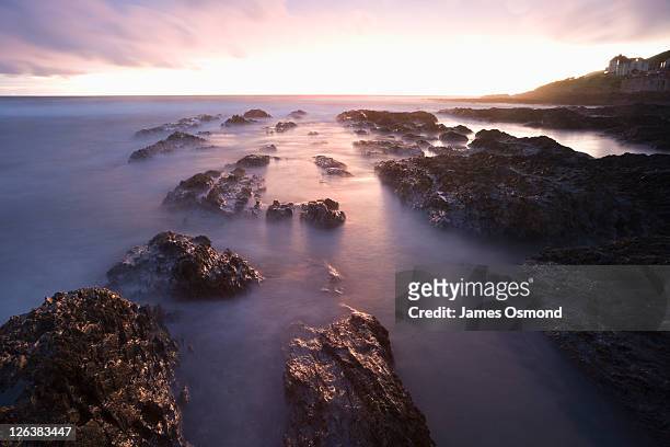 sunset over the rocks at croyde bay in devon. - croyde stock pictures, royalty-free photos & images