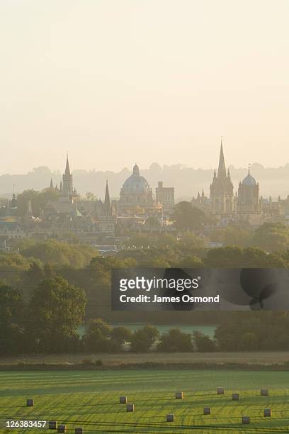 a misty view over the fields toward the oxford skyline at sunrise. - oxford england stock pictures, royalty-free photos & images