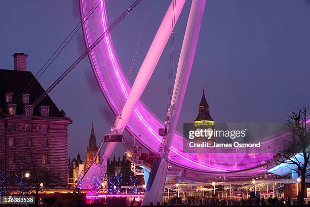 the palace of westminster clock tower, big ben, seen through the london eye illumintaed at night, at wintertime in the nation's capital city - south bank london stock pictures, royalty-free photos & images