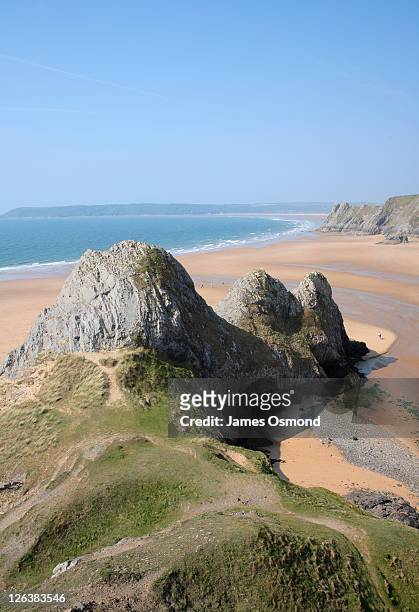 view across the three cliffs bay on the gower peninsula, at low tide, on the south wales coastline - gower peninsula stock pictures, royalty-free photos & images