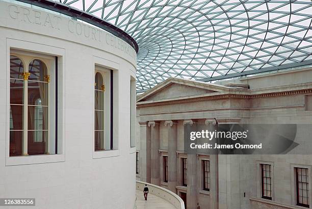 lone figure wandering in the vast space of the the great court, surrounding the reading room at the british museum in london - british museum stock pictures, royalty-free photos & images