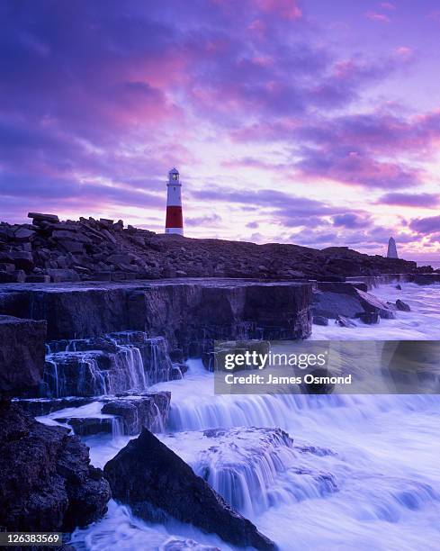 twilight over the portland bill lighthouse, dating back to 1906, and white stone obelisk built by trinity house in 1844 to mark a low rock shelf extending into the sea on dorset's jurassic coast, a world heritage site - insel portland england stock-fotos und bilder