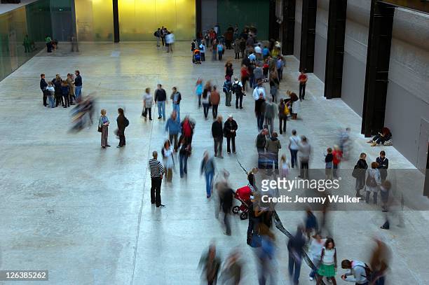 a crowd of people in the main turbine hall of the tate modern art gallery. - turbine hall stock pictures, royalty-free photos & images