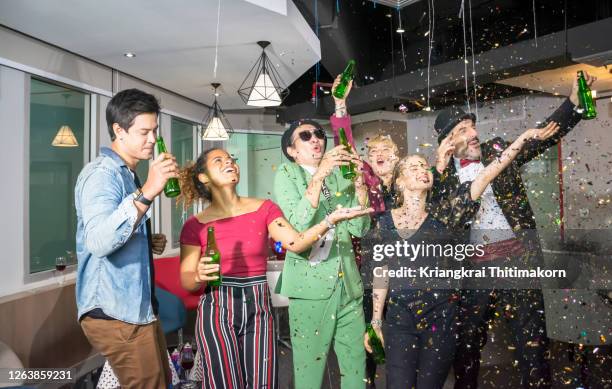 business colleagues socializing at office party. - southeast asia office stock pictures, royalty-free photos & images