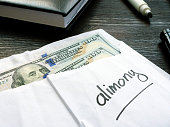 Alimony concept. Open envelope with cash on the desk.