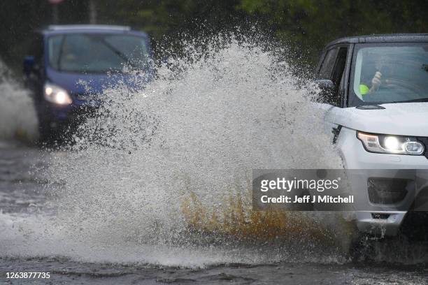 Cars make their way through flood water following torrential rain on the A760 road near to Lochwinnoch on August 2, 2020 in Lochwinnoch, Scotland....