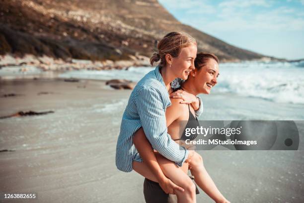 portret van het gelukkige paar op het strand - lesbische stockfoto's en -beelden