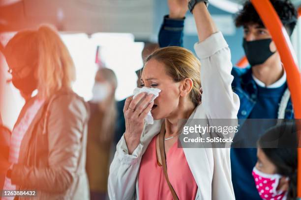 woman sneezing on public transport - sneeze stock pictures, royalty-free photos & images