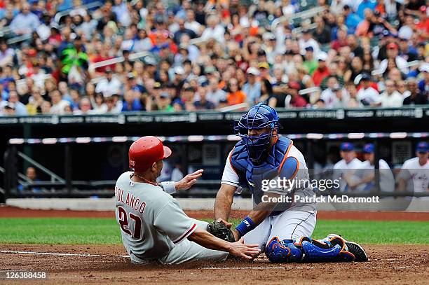 Placido Polanco of the Philadelphia Phillies is tagged out at home plate by Ronny Paulino of the New York Mets in the third inning at Citi Field on...
