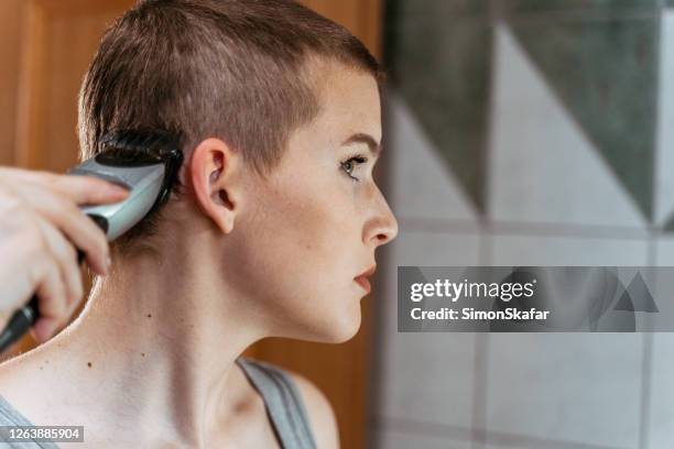 young woman shaving her head - electric razor stock pictures, royalty-free photos & images