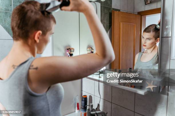 mirror reflection of woman shaving her hair - electric razor stock pictures, royalty-free photos & images