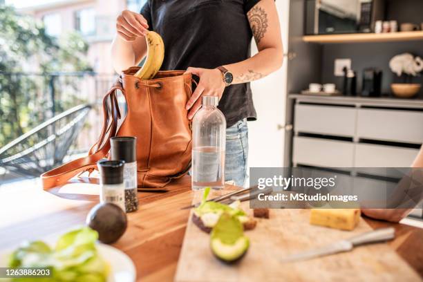 woman putting her fruit snack in a bag - lunch bag stock pictures, royalty-free photos & images