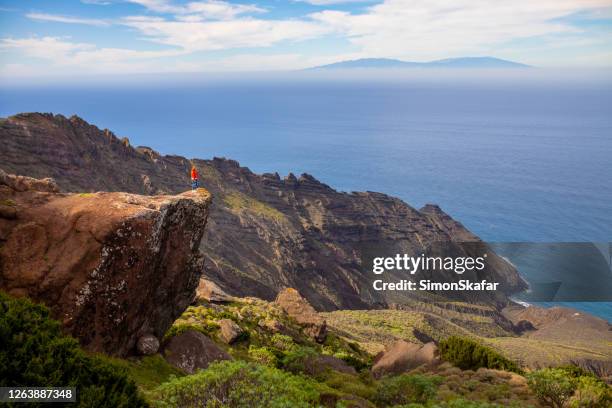person standing on edge of rock. man looking at sea view. la gomera, canary islands, spain - gomera canary islands stock pictures, royalty-free photos & images