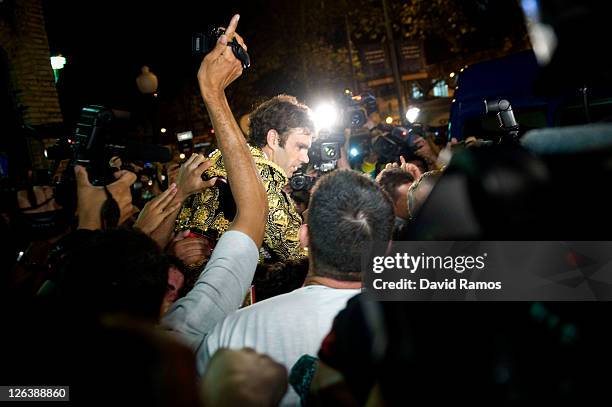 Bullfighter Jose Tomas leaves the bullring carried on the shoulders of a supporter at the end of the last bullfight at the La Monumental on September...