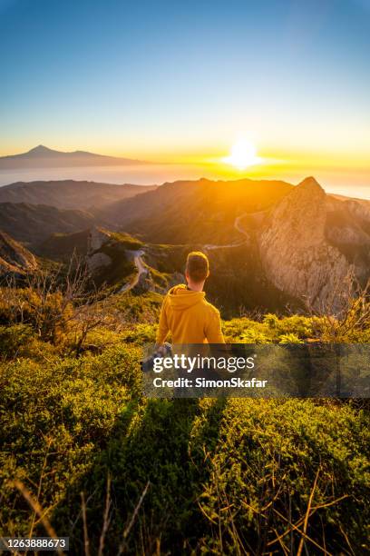 man with camera in mountains at sunrise, la gomera, canary islands, spain - gomera canary islands stock pictures, royalty-free photos & images