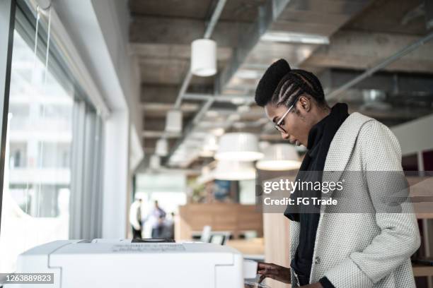 joven empresaria que usa impresora informática - printer fotografías e imágenes de stock