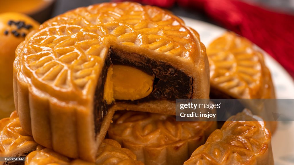 Smakelijke gebakken eidooiergebakjemaancake voor Mid-De Festival van de herfst op zwarte leisteen donkere achtergrond. Chinees feestelijk voedselconcept, sluit omhoog, exemplaarruimte.