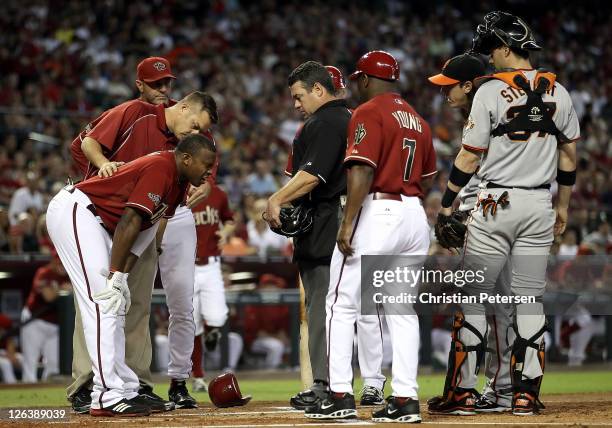 Justin Upton of the Arizona Diamondbacks is looked at by a team trainer after being hit in the head by a pitch from pitcher Tim Lincecum of the San...