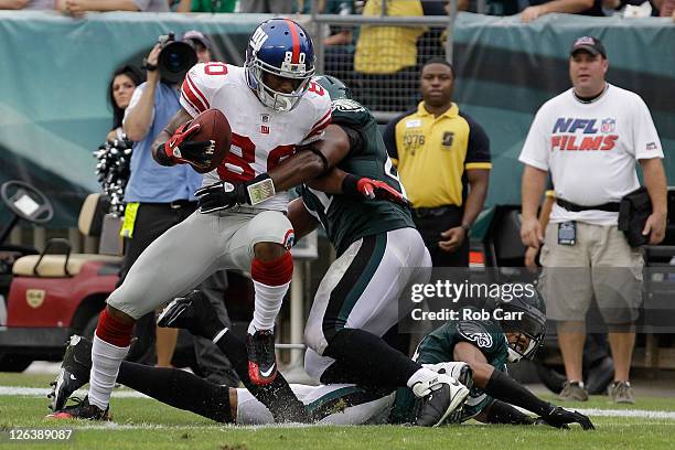 Victor Cruz of the New York Giants scores a touchdown against Jarrad Page of the Philadelphia Eagles and Nnamdi Asomugha during the fourth quarter at...