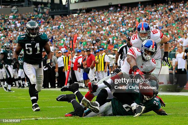 Victor Cruz of the New York Giants catches a 28 yard touchdown pass in the fourth quarter over Nnamdi Asomugha and Jarrad Page of the Philadelphia...