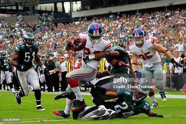 Victor Cruz of the New York Giants catches a 28 yard touchdown pass in the fourth quarter over Nnamdi Asomugha and Jarrad Page of the Philadelphia...