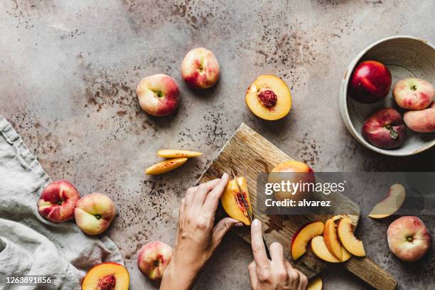 woman cutting slices of peaches - fructose stock pictures, royalty-free photos & images