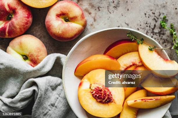 rebanadas de duraznos maduros en un tazón. - chopped food fotografías e imágenes de stock