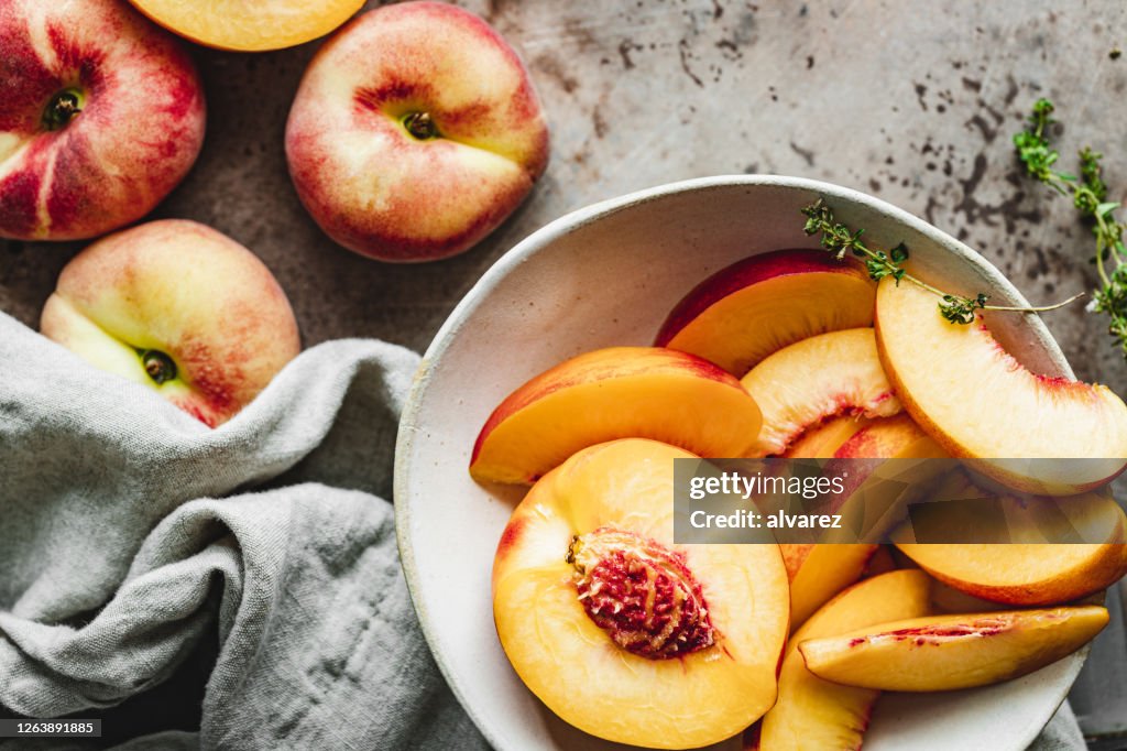 Slices of ripe peaches in a bowl.