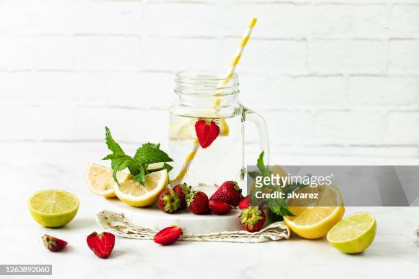 eigengemaakte limonade van de aardbeimunt - infused water stockfoto's en -beelden