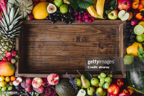 tropical fruits around empty wooden box - tropical fruit stock pictures, royalty-free photos & images