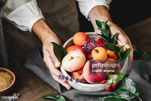 vrouw met een kom verse vruchten - fruitschaal stockfoto's en -beelden