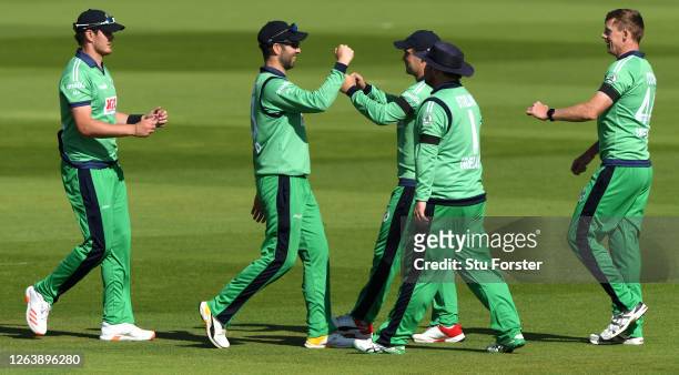 Catcher Mark Adair , bowler Craig Young and Andrew Balbirnie of Ireland celebrate the wicket of Sam Billings of England with teammates during the...