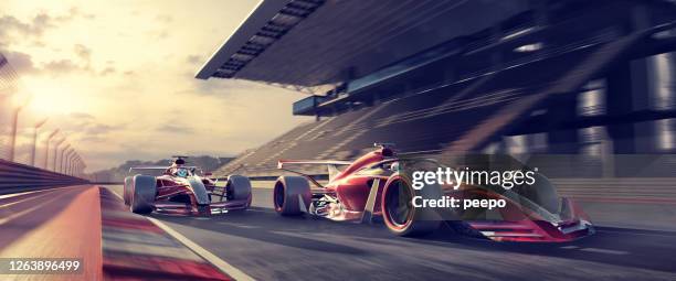 racing cars moving fast on racetrack near grandstand at sunset - motorized sport imagens e fotografias de stock