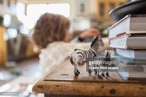 4 year old boy wearing pajamas playing with toys at home - toy animal stockfoto's en -beelden