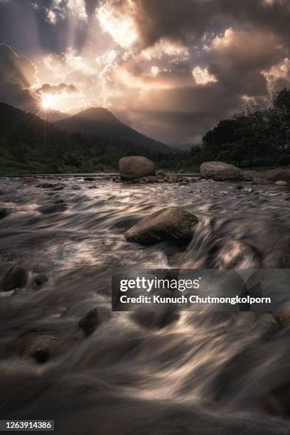 wonderful canal stream in dramatic evening sky and sun burst. - kiriwong stock pictures, royalty-free photos & images